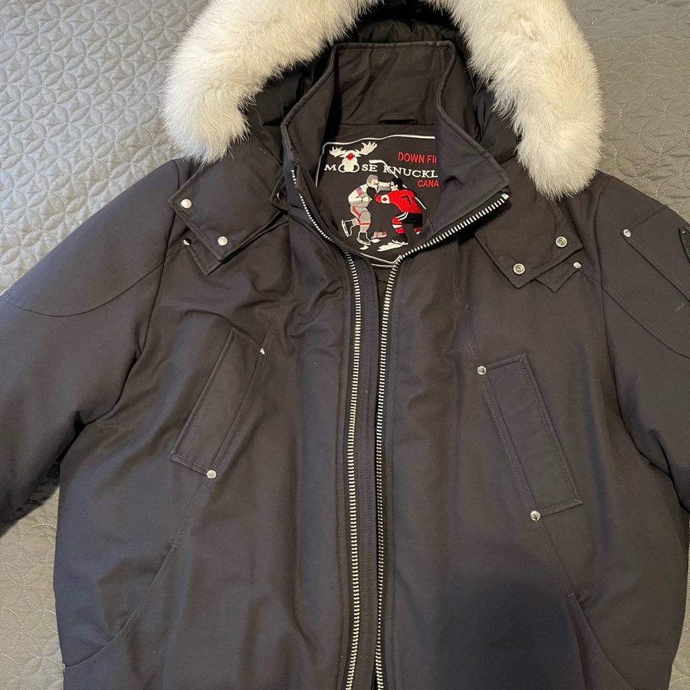Black men’s Moose knuckle jacket with white fur trim. Size XXL